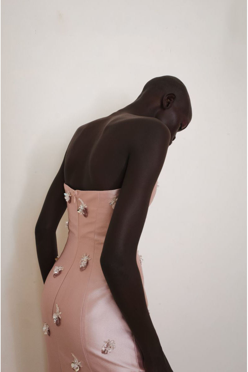 Close-up of the pink Flicker Gown by Yassmin Saleh, showing detailed back design and elegant fabric texture.