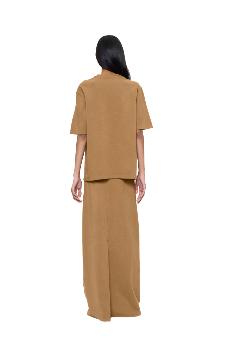 Back view of URA FLO maxi skirt in sandy beige fabric, flowing and elegant, showcasing its length and soft drape.