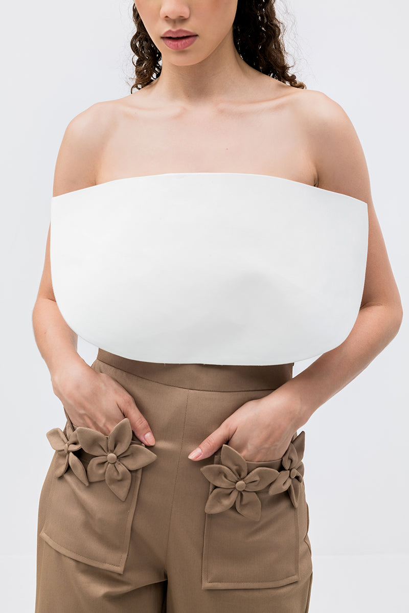 Tan floral pants by ANA + MARIA featuring a high-waisted design and vibrant floral pattern, shown on a model.