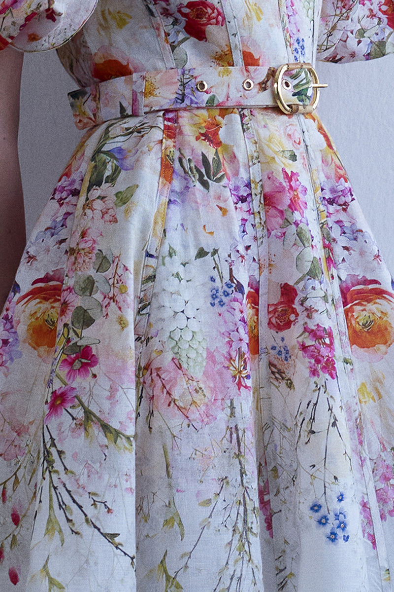 AISA Florelle midi dress in floral print, flowing fabric with long sleeves, shown on a hanger against a neutral background.