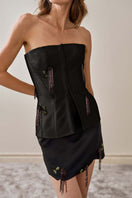Close-up of YASSMIN SALEH black fold mini skirt showing soft fabric and stylish design detail.