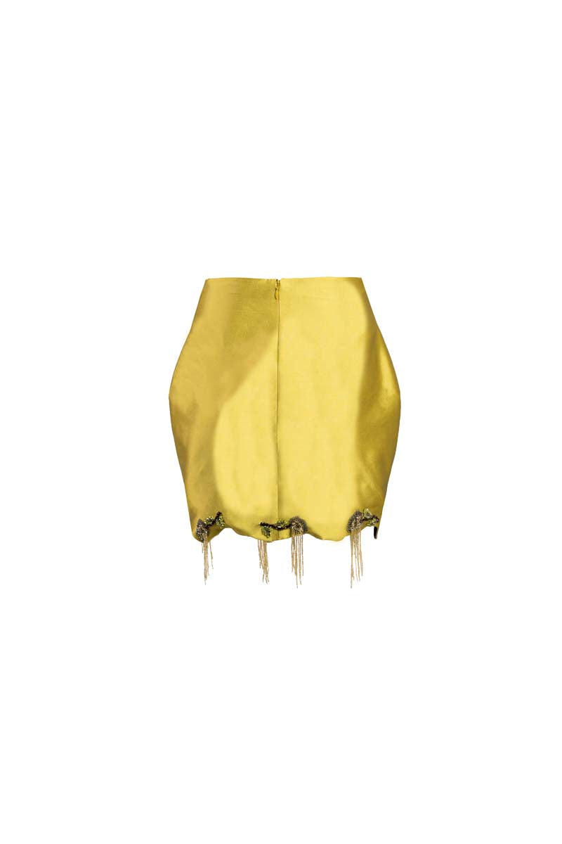 Green fold mini skirt by Yassmin Saleh, shown with a stylish back view and folded design detail.