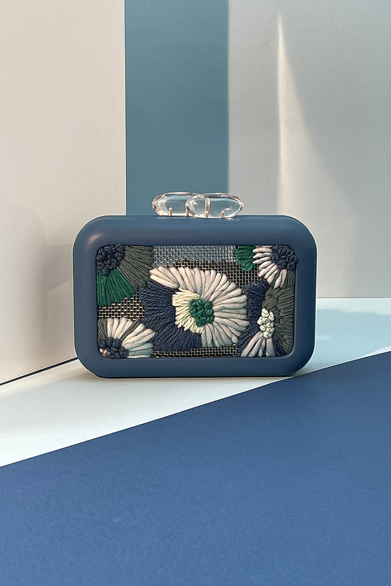 Blue Folhata Flora Grid clutch bag by Sy&Vie featuring a geometric pattern and compact design for stylish carrying.