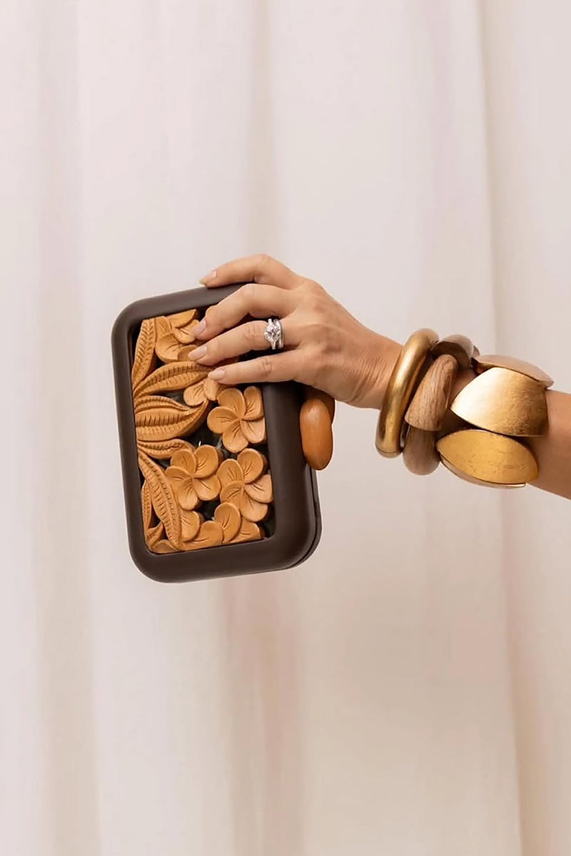 Brown acrylic clutch with hibiscus floral design by Sy&Vie, featuring a sleek, compact style perfect for evening accessories.