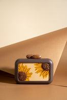 Brown clutch with sunflower embroidery from Sy&Vie, featuring intricate floral details and a sleek design.