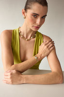 Green Maravilla wide bracelet by Álvaro Ávila featuring intricate design and craftsmanship, shown on a neutral background.