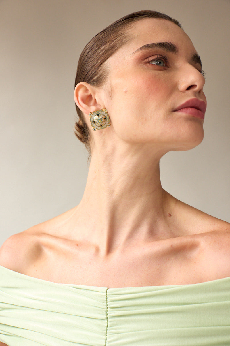 Green protector stud earrings by Álvaro Ávila featuring small, secure stud design with protective detail on a plain background.