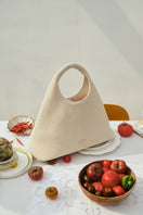 White POELLE Francesca top handle bag with sleek design and gold hardware, featuring a structured shape and elegant carry handle.