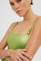 Shiny green Frey one-piece swimsuit by Maliluha featuring a sleek fit and stylish design, perfect for beach or poolwear.