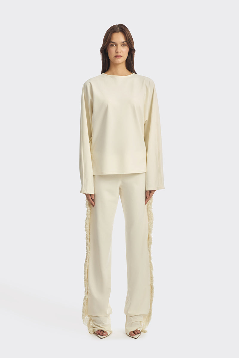 Ivory white long sleeve top with fringe details from Stolen Stores, featuring a boho-inspired design and relaxed fit.