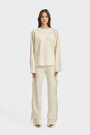 Ivory white long sleeve top with fringe details from Stolen Stores, featuring a boho-inspired design and relaxed fit.