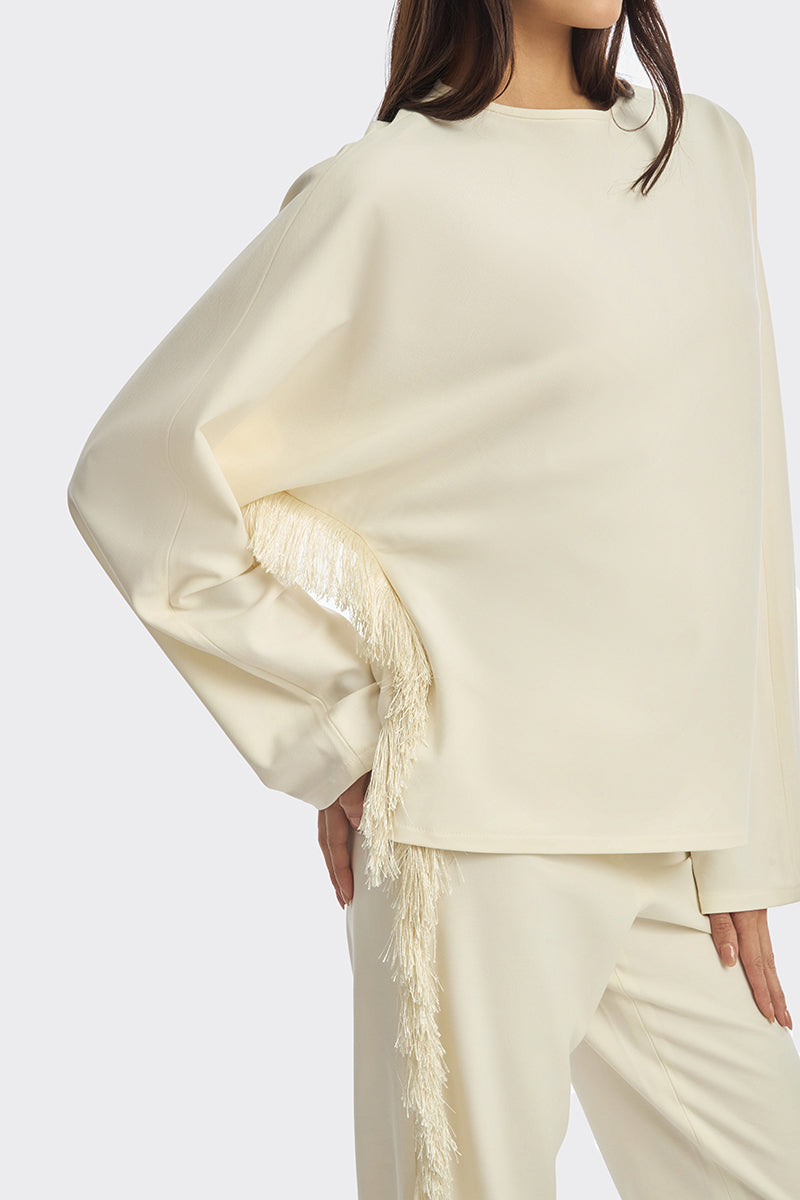 Ivory white long-sleeve top with fringe details from Stolen Stores, featuring a stylish and bohemian-inspired design.