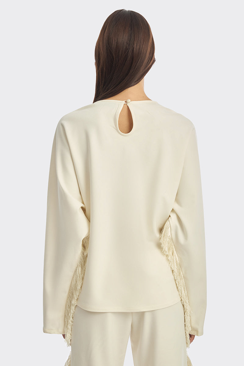Ivory white long sleeve top with fringe details from Stolen Stores, featuring a relaxed fit and stylish boho-inspired design.