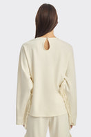 Ivory white long sleeve top with fringe details from Stolen Stores, featuring a relaxed fit and stylish boho-inspired design.