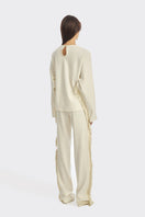 Ivory white long-sleeve top with fringe details from Stolen Stores, featuring a bohemian style and relaxed fit.