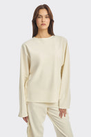 Ivory white long-sleeve top with thread fringe detailing from Stolen Stores, showcasing a stylish boho-inspired blouse.