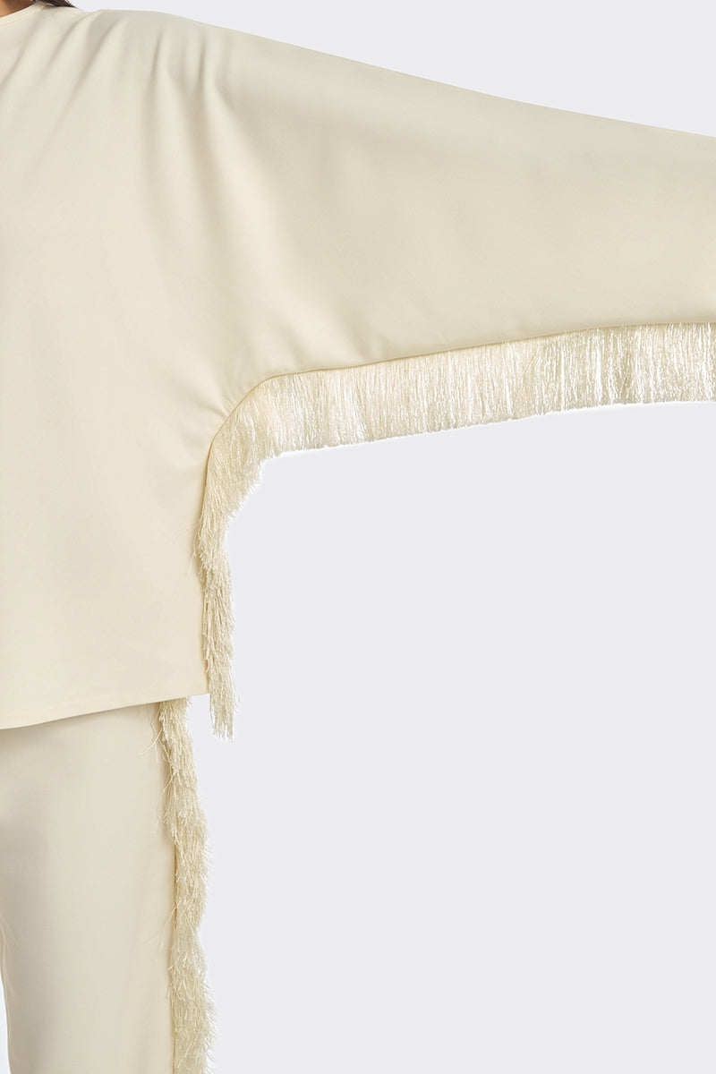 Ivory white long-sleeve top with fringe detailing from Stolen Stores, featuring a stylish and bohemian-inspired design.