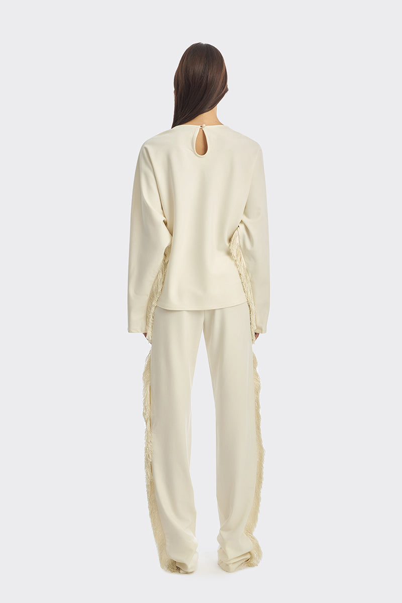 Ivory white long sleeve top with fringe details from Stolen Stores, featuring a stylish and bohemian-inspired design.