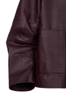 Wine red leather blazer by MAZ Manuela Álvarez, styled with lapels and tailored fit in a close-up of the Furrows leather blazer.