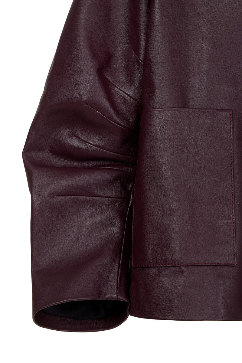 Wine red leather blazer by MAZ Manuela Álvarez, styled with lapels and tailored fit in a close-up of the Furrows leather blazer.