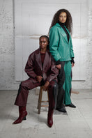 Wine red leather blazer by MAZ Manuela Álvarez featuring tailored fit and stylish lapels, displayed on a hanger.