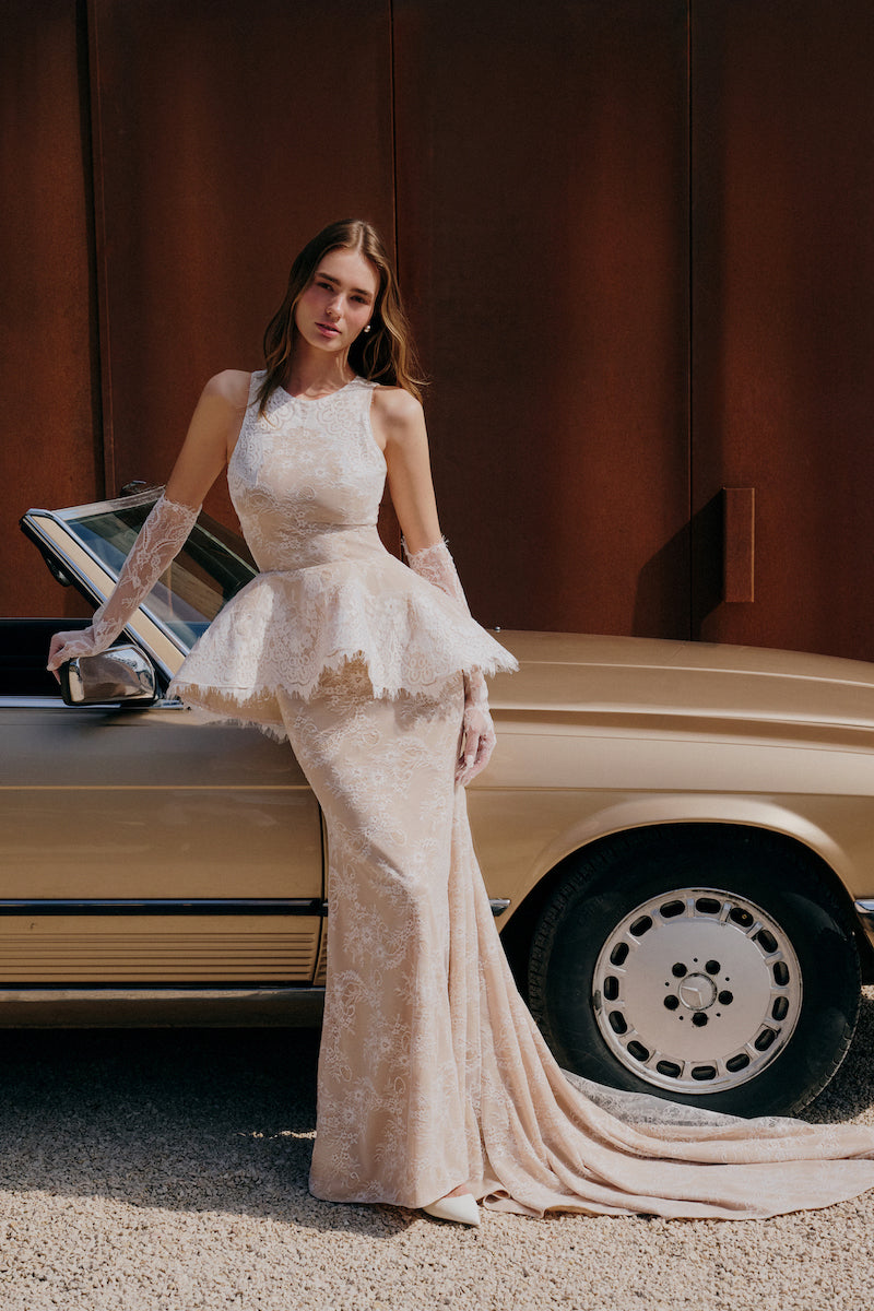 Elegant lace gown by Gigii's featuring intricate lace details and a flowing silhouette, perfect for formal occasions.
