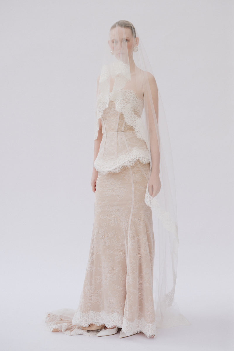 Elegant lace Sabrina gown by Gigii's featuring intricate lace details and a flowing silhouette, perfect for formal occasions.