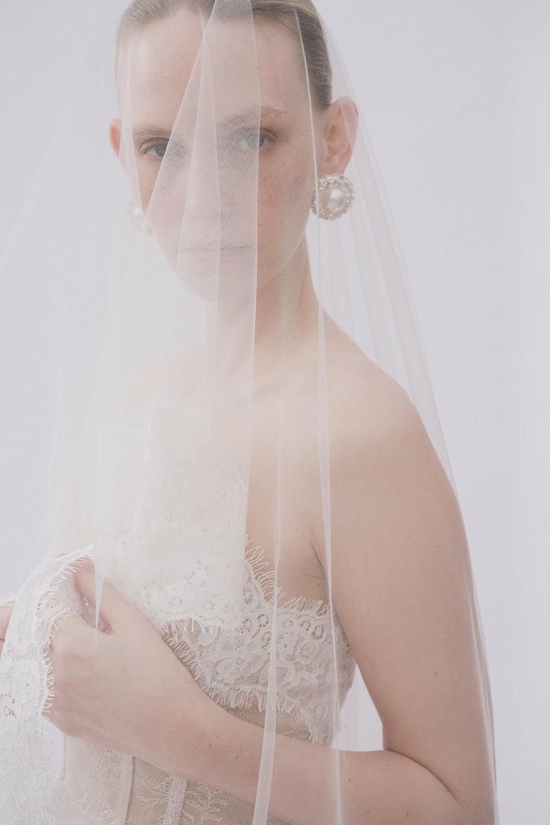 Elegant lace Sabrina gown by Gigii's featuring intricate lace details and a flowing silhouette.