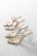 Beige Fiorellini Glass Mule 95 sandals by House of Atana with clear glass heel and wheat patent leather straps.