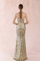 Elegant gold strapless long gown by HACCHIC COUTURE, featuring flowing fabric and sophisticated design.