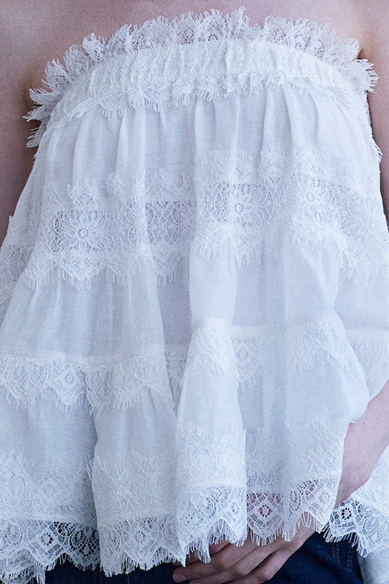 White AISA Grace top displayed on a hanger, showcasing its stylish design and lightweight fabric.