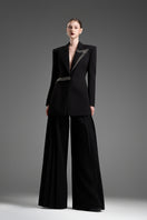 Black GVLUX multi-pleat wide-leg trousers, stylish pants with a relaxed fit and pleated design, shown on a model.