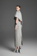 Light gray asymmetric draped cape sleeve column maxi dress by GVLUX, featuring elegant flowing fabric and modern design.