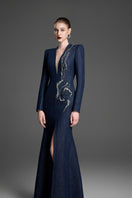Dark blue V-neck mermaid gown with crystal embellishments by GVLUX, featuring a fitted silhouette and elegant design.
