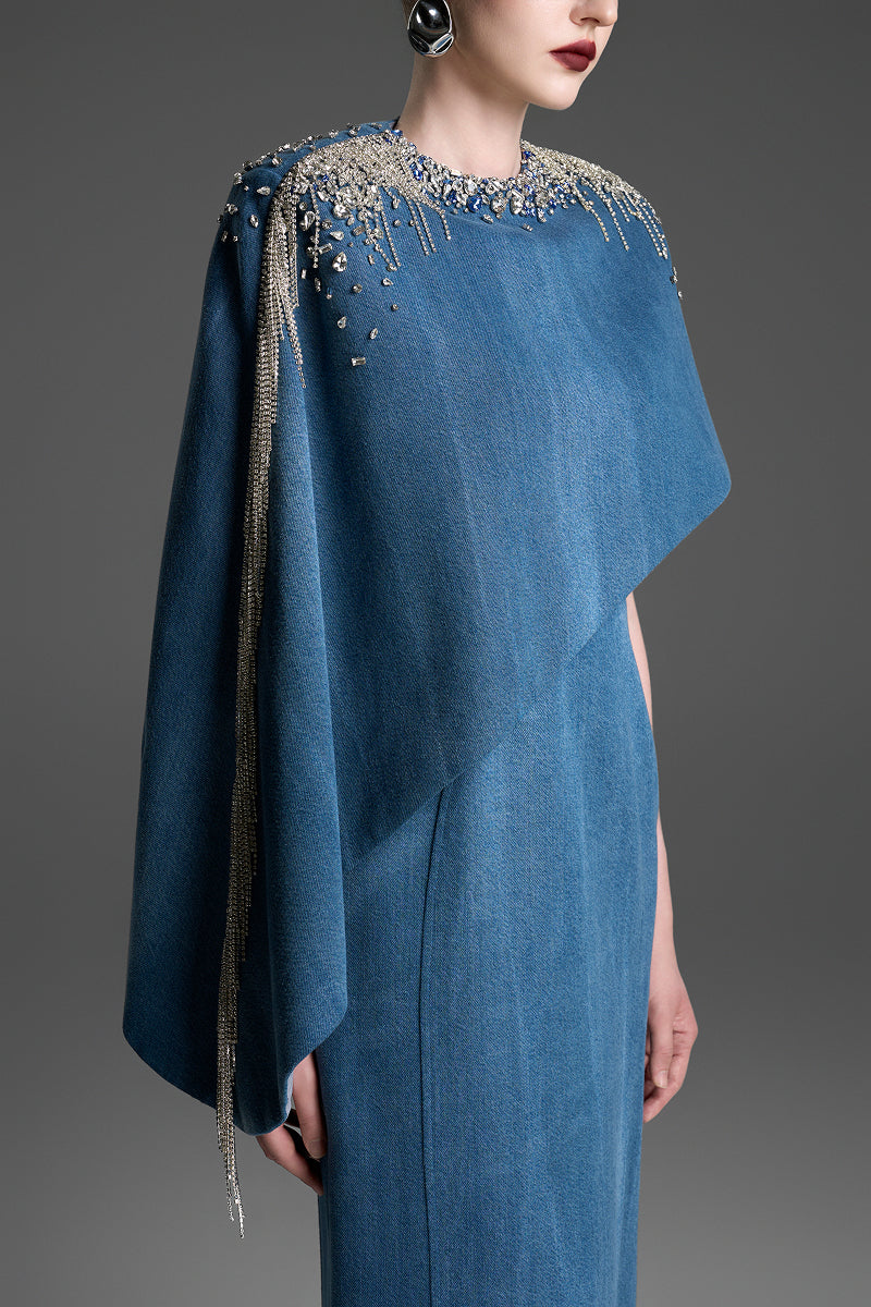 Blue asymmetrical column maxi dress with draped cape sleeve by GVLUX, featuring elegant and modern design.