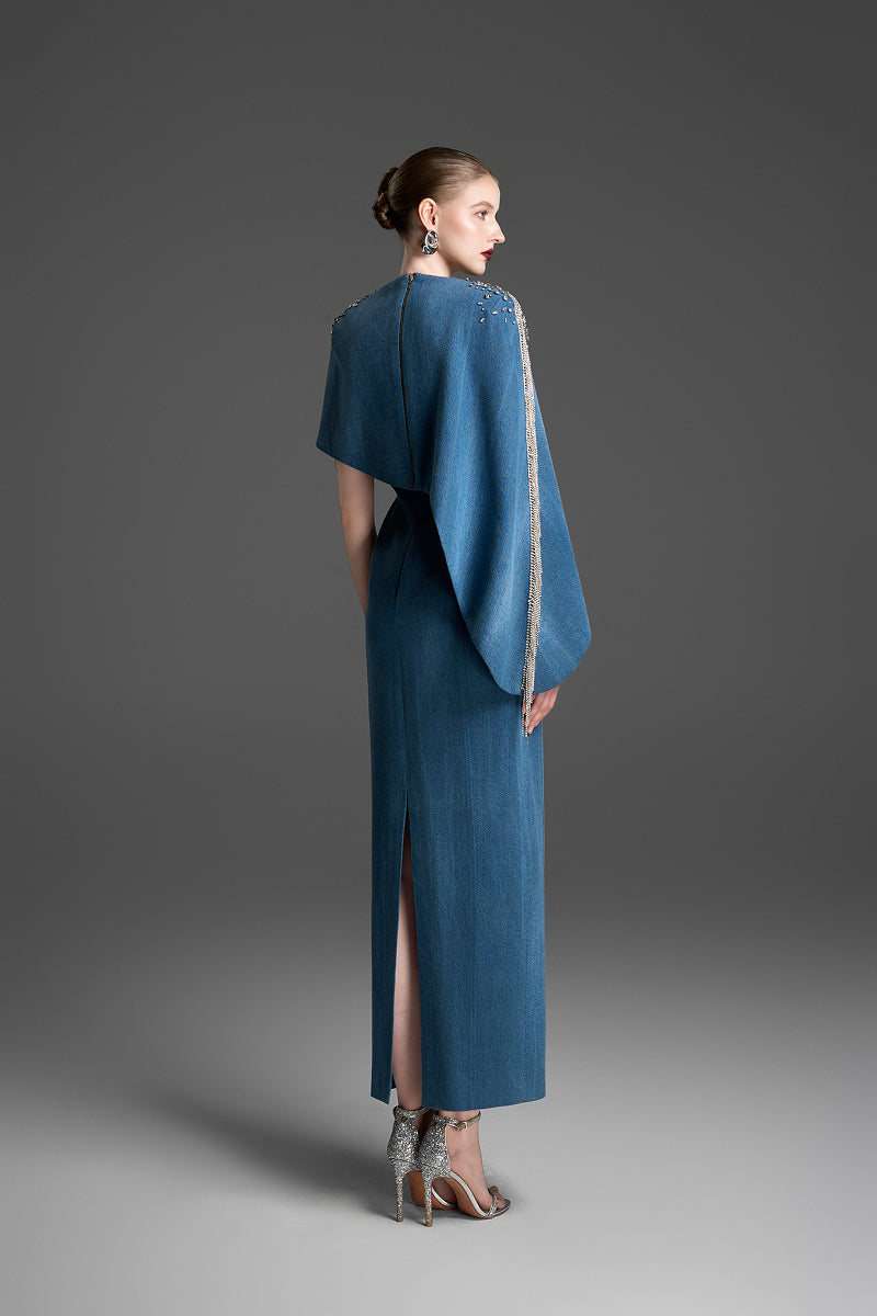 Blue asymmetrical column maxi dress with draped cape sleeves by GVLUX, featuring a sleek, elegant silhouette.
