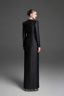 Black sheath gown with a wave neckline by GVLUX, featuring a sleek, fitted silhouette and elegant design.