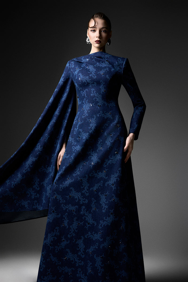 Navy embroidered cape shoulder gown by GVLUX featuring intricate embroidery and flowing fabric for elegant occasions.