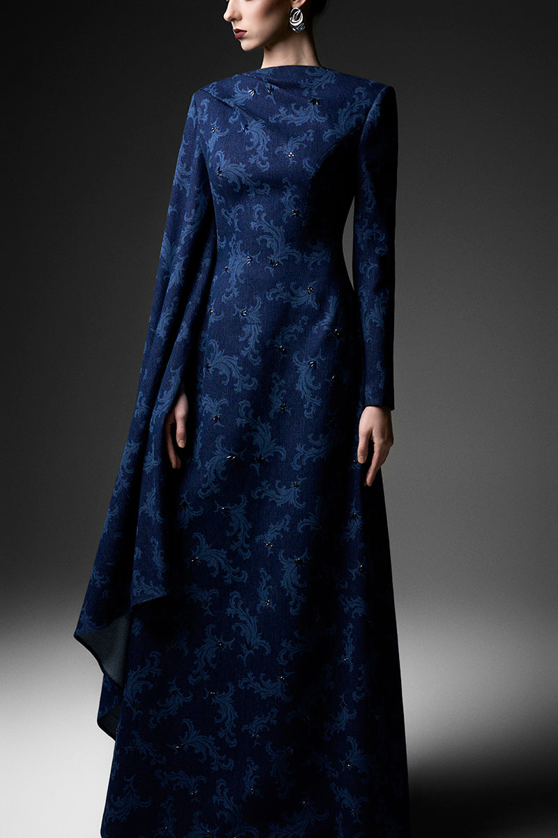 Navy embroidered gown with cape shoulders by GVLUX, elegant formal dress with intricate embroidery and flowing fabric.