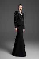 Black paneled construction mermaid maxi skirt by GVLUX, featuring a fitted silhouette and layered design.