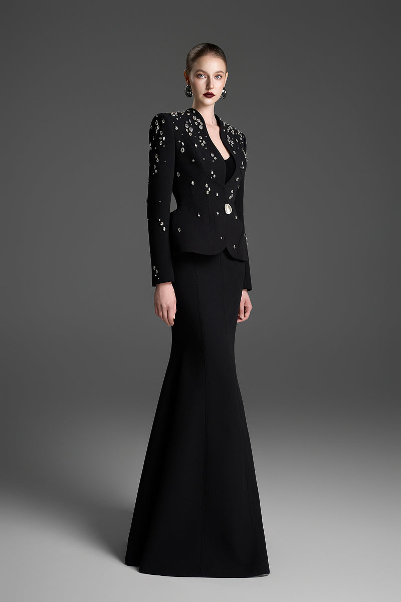 Black paneled construction mermaid maxi skirt by GVLUX, featuring a fitted silhouette and layered design.