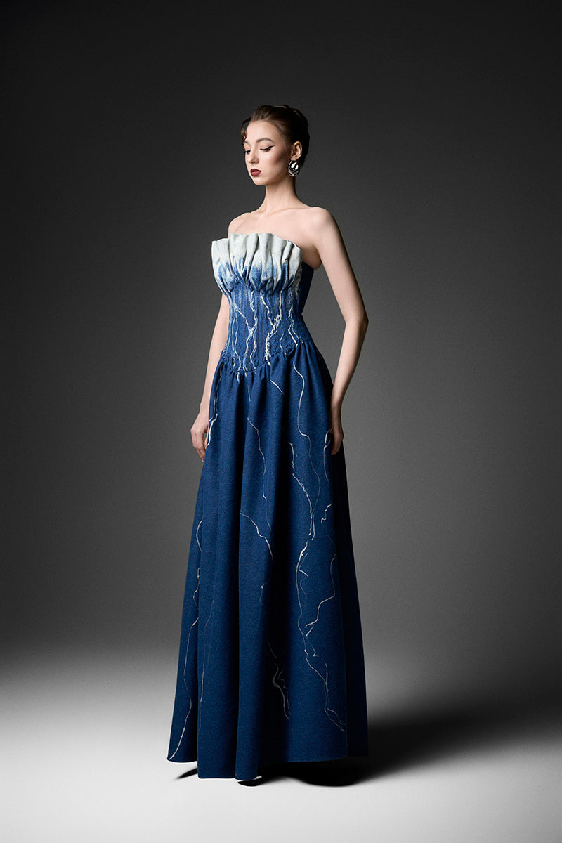 Elegant midnight strapless gown by GVLUX, featuring a flowing design and fitted bodice, perfect for formal occasions.