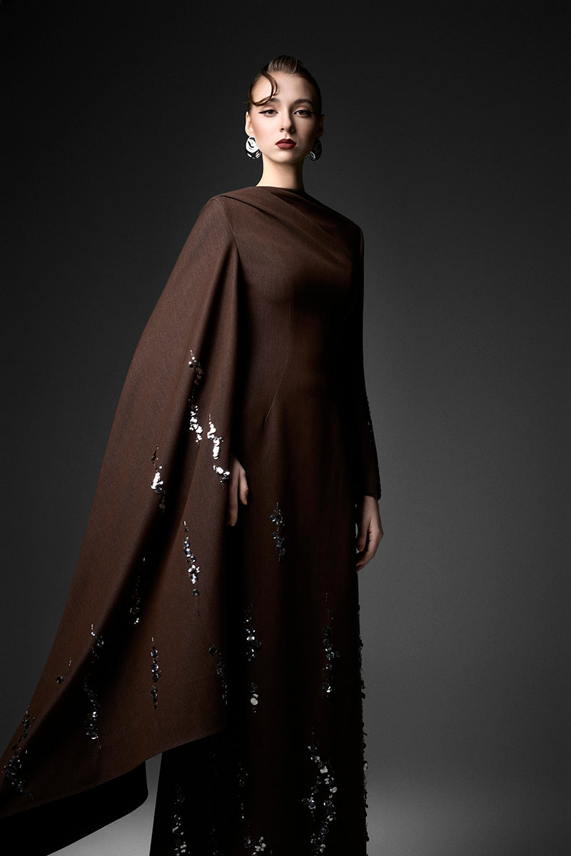Elegant deep tone embroidered gown by GVLUX with intricate embroidery and flowing fabric, perfect for formal occasions.