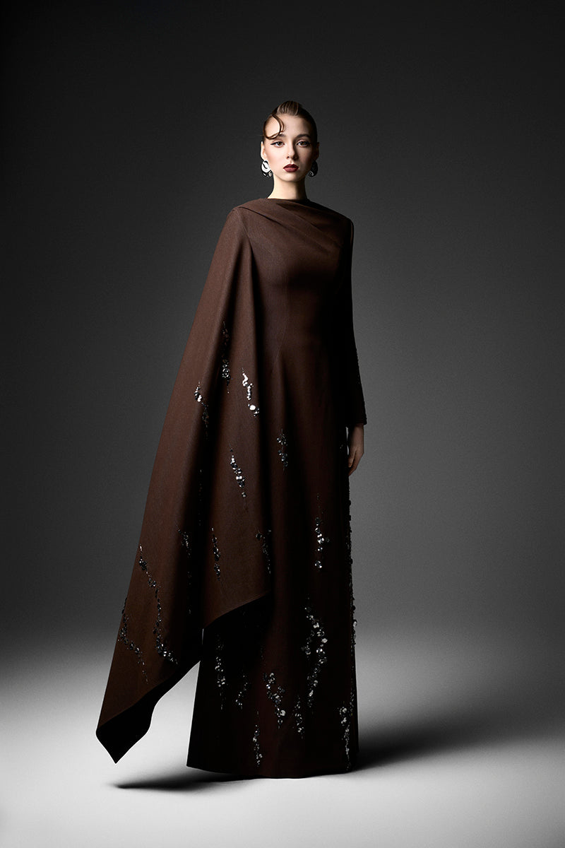 Elegant deep tone embroidered gown by GVLUX, featuring intricate embroidery and flowing fabric for formal occasions.