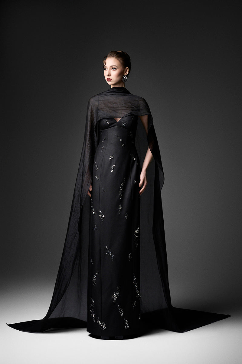 Black Cape Neck Column Gown by GVLUX, elegant floor-length dress with sleek silhouette and cape detail, perfect for formal occasions.