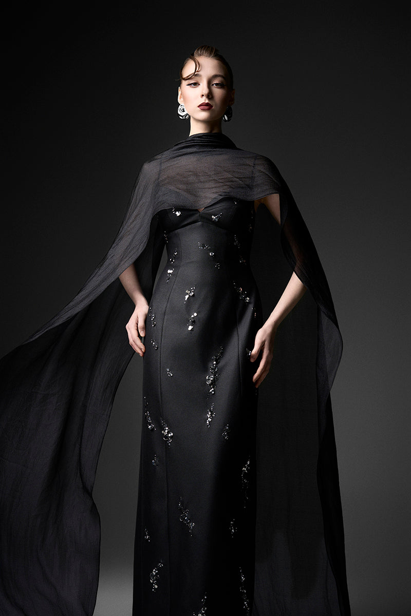 Black Cape Neck column gown by GVLUX featuring sleek fabric and elegant drape, perfect for formal occasions.