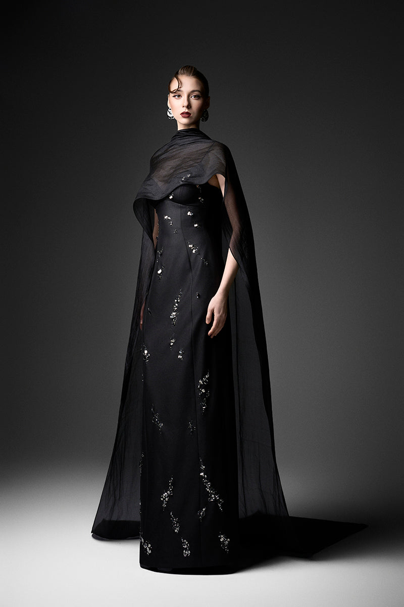 Black Cape Neck Column Gown by GVLUX, elegant evening dress featuring a sleek silhouette and cape detail, perfect for formal occasions.