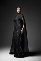 Black Cape Neck Column Gown by GVLUX, elegant evening dress featuring a sleek silhouette and cape detail, perfect for formal occasions.