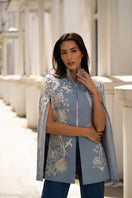 Nadya Shah Gabrielle in Denim Dream Cape jacket made of denim with flowing design, showcased on a model against a neutral background.