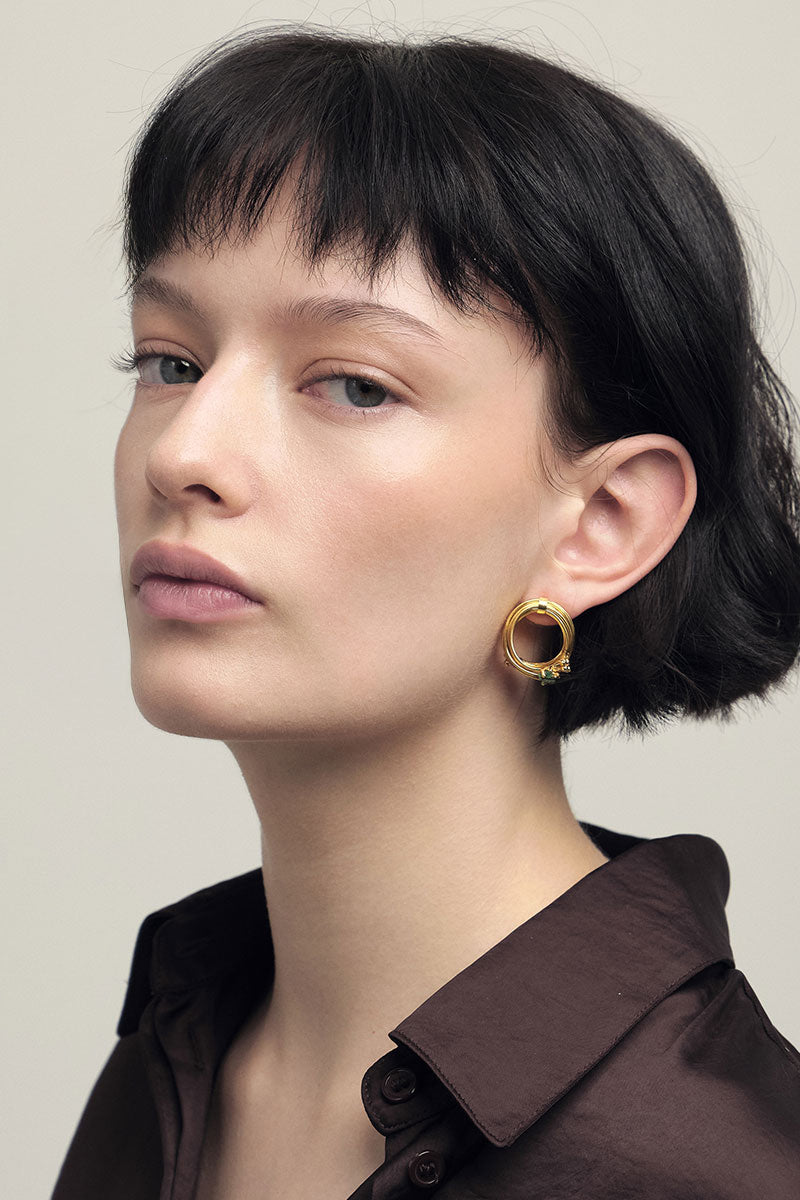 Gold GEO emerald earrings by Fenomena featuring geometric design and vibrant green emerald stones.